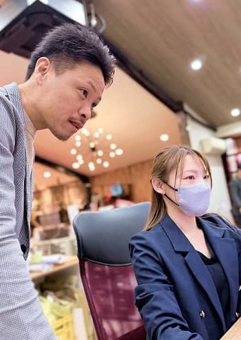 スタッフ2人がパソコンの画面を見ながら相談をしている様子