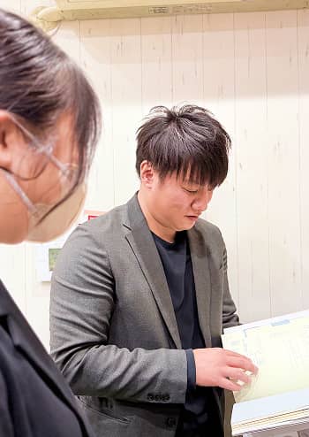 スタッフ2人が資料を見ながら相談している様子